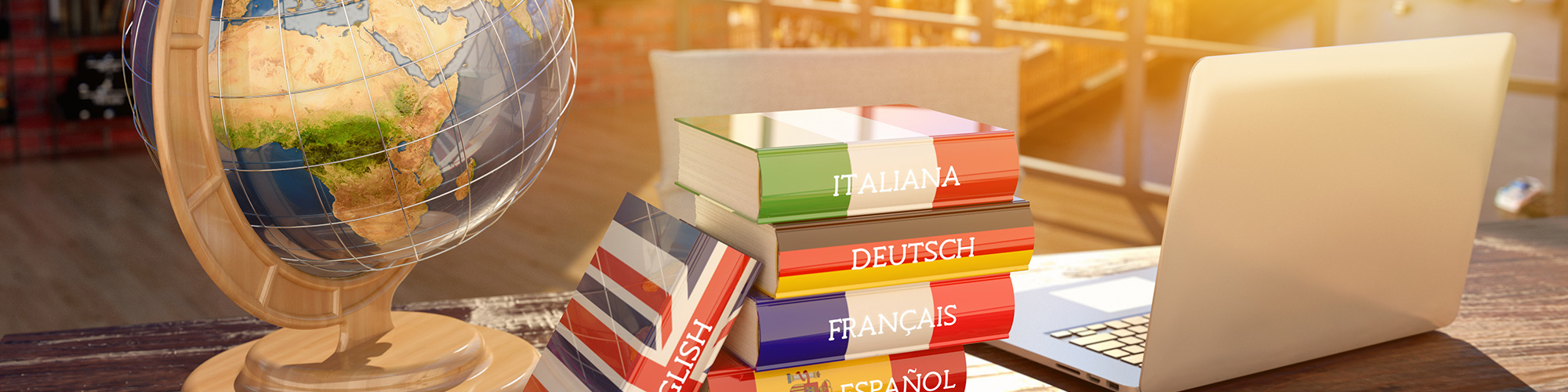 Globus, sechs Wörterbücher und Laptop auf Holztisch in Loft